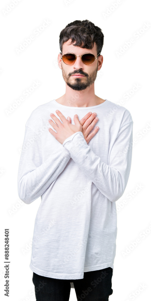 Young handsome man wearing sunglasses over isolated background smiling with hands on chest with closed eyes and grateful gesture on face. Health concept. Young handsome man wearing sunglasses over isolated background smiling with hands on chest with closed eyes and grateful gesture on face. Health concept.