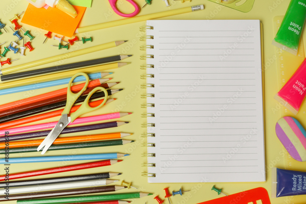 Back to school concept with variety of office and school supplies on yellow background. Back to school concept with variety of office and school supplies on yellow background.