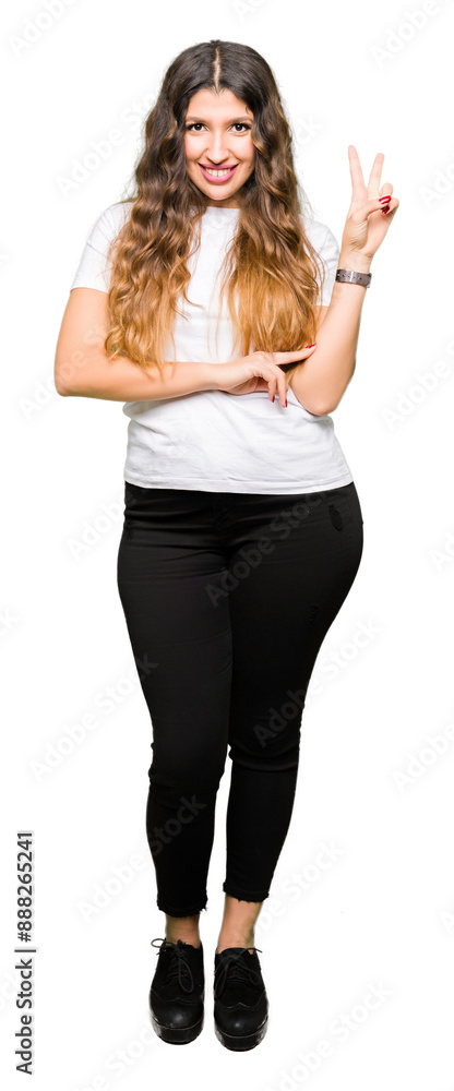 Young beautiful woman wearing casual white t-shirt smiling with happy face winking at the camera doing victory sign. Number two. Young beautiful woman wearing casual white t-shirt smiling with happy face winking at the camera doing victory sign. Number two.