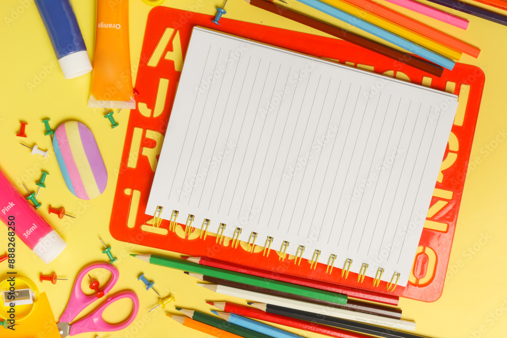 Back to school concept with variety of office and school supplies on yellow background. Back to school concept with variety of office and school supplies on yellow background.
