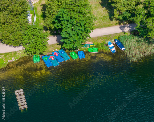 Aerial view of pedal boats parked on the shore of Galve lake, Trakai, Lithuania. Top up view of hydrocycle water bikes photo