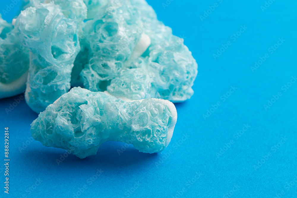 Crunchy Freeze Dried Gummy Shaped Sharks on a Blue Background Crunchy Freeze Dried Gummy Shaped Sharks on a Blue Background