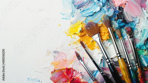 Fototapeta Naklejka Na Ścianę i Meble -  Vibrant oil paint palette and brushes against white backdrop