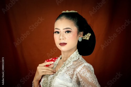 A young Indonesian woman with a happy expression wearing a white kebaya. Kartini's Day Concept. photo