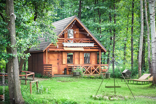 A summer house surrounded by a green forest. Cottage for rent. A cottage in the forest. House by the lake. A wooden house for relaxation.