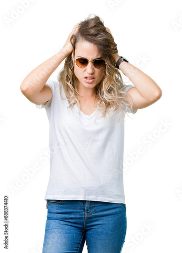 Beautiful young blonde woman wearing sunglasses over isolated background suffering from headache desperate and stressed because pain and migraine. Hands on head.