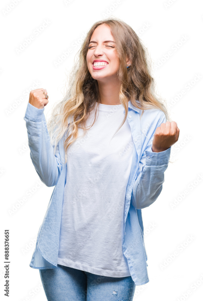 Beautiful young blonde woman over isolated background very happy and excited doing winner gesture with arms raised, smiling and screaming for success. Celebration concept. Beautiful young blonde woman over isolated background very happy and excited doing winner gesture with arms raised, smiling and screaming for success. Celebration concept.