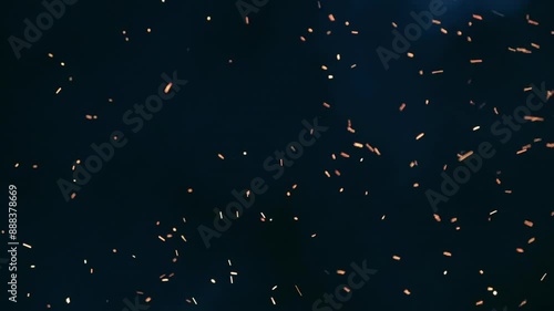 Sparks of fire on a dark background, burning yellow sparks in the night. Screen saver to the end of the film. The concept of completion.