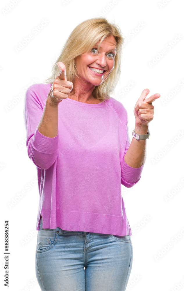 Middle age blonde woman over isolated background pointing fingers to camera with happy and funny face. Good energy and vibes.
