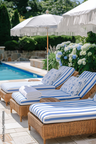 Outdoor pool area with modern furniture  surrounded by garden with flowers and trees