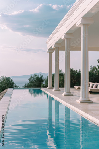 Blue water swimming pool surrounded by a classic style villa with columns