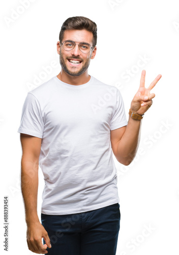 Young handsome man wearing glasses over isolated background smiling with happy face winking at the camera doing victory sign. Number two.