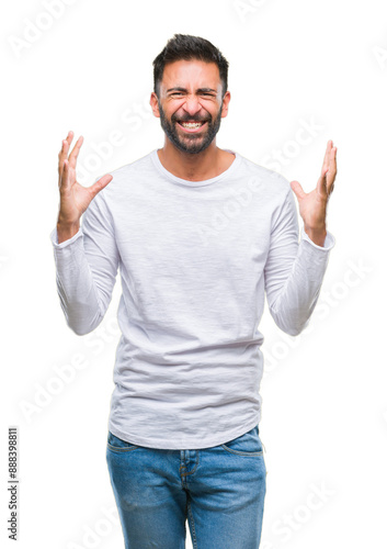 Adult hispanic man over isolated background crazy and mad shouting and yelling with aggressive expression and arms raised. Frustration concept.