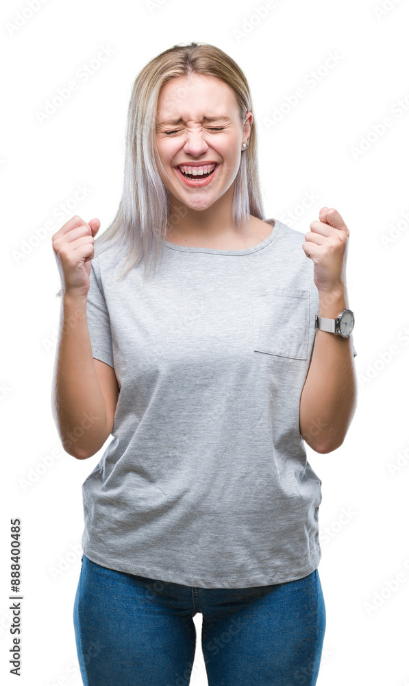 Young blonde woman over isolated background excited for success with arms raised celebrating victory smiling. Winner concept. Young blonde woman over isolated background excited for success with arms raised celebrating victory smiling. Winner concept.