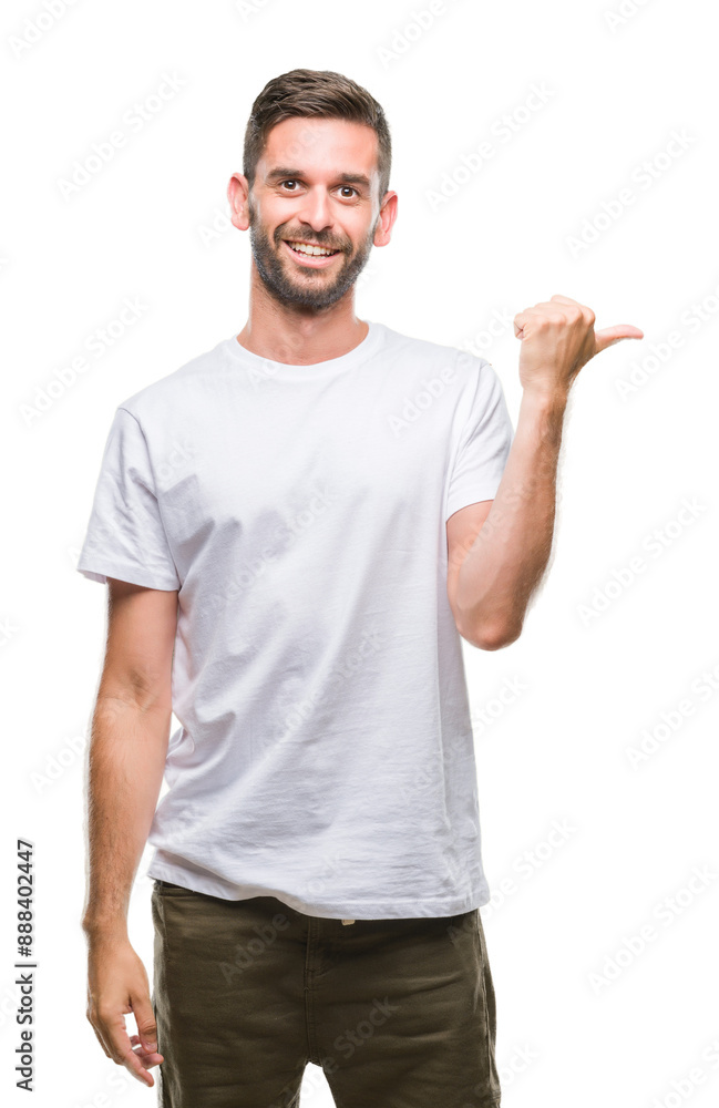 Young handsome man over isolated background smiling with happy face looking and pointing to the side with thumb up. Young handsome man over isolated background smiling with happy face looking and pointing to the side with thumb up.