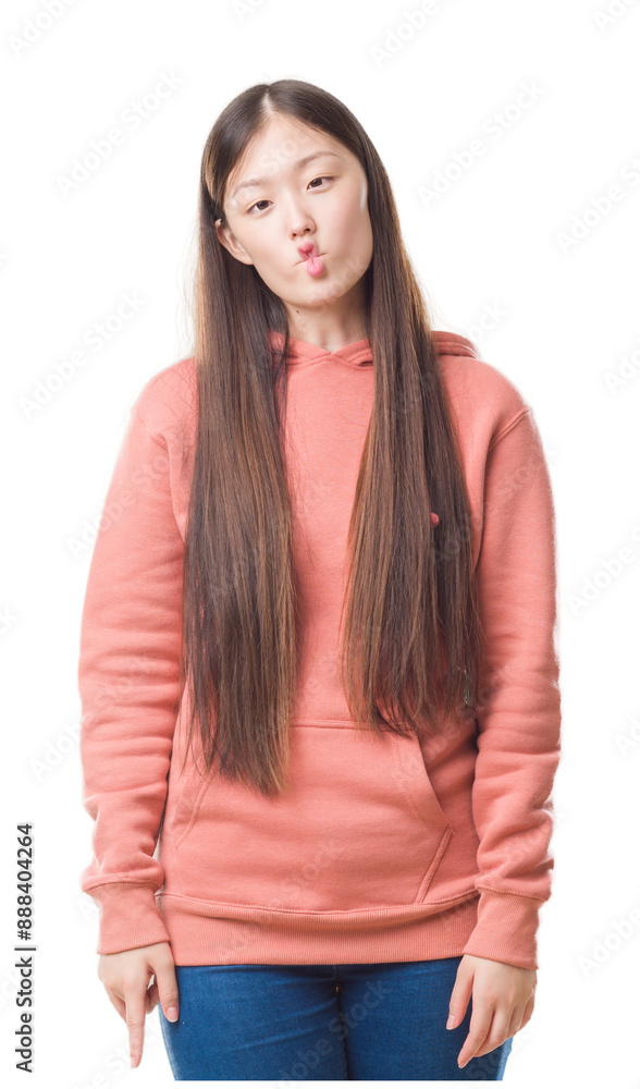 Obraz premium Young Chinese woman over isolated background wearing sport sweathshirt making fish face with lips, crazy and comical gesture. Funny expression.