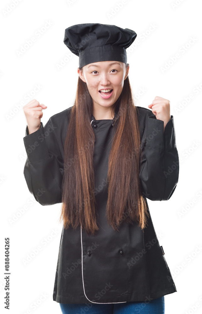 Young Chinese woman over isolated background wearing chef uniform celebrating surprised and amazed for success with arms raised and open eyes. Winner concept. Young Chinese woman over isolated background wearing chef uniform celebrating surprised and amazed for success with arms raised and open eyes. Winner concept.