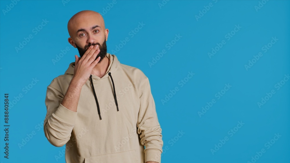 Lovely sweet person blowing air kisses on camera, dping romantic gesture and being flirty over blue background. Middle eastern guy sending a kiss to express his honest feelings. Camera 1. Lovely sweet person blowing air kisses on camera, dping romantic gesture and being flirty over blue background. Middle eastern guy sending a kiss to express his honest feelings. Camera 1.