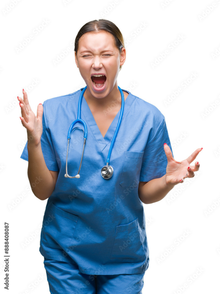 Young caucasian doctor woman wearing medical uniform over isolated background crazy and mad shouting and yelling with aggressive expression and arms raised. Frustration concept. Young caucasian doctor woman wearing medical uniform over isolated background crazy and mad shouting and yelling with aggressive expression and arms raised. Frustration concept.