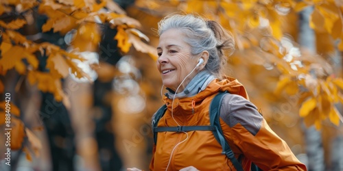 Senior Woman Jogging Through Autumn Foliage While Listening to Music