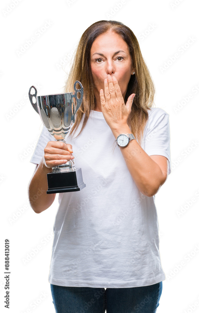 Middle age hispanic winner woman celebrating award holding trophy over isolated background cover mouth with hand shocked with shame for mistake, expression of fear, scared in silence, secret concept Middle age hispanic winner woman celebrating award holding trophy over isolated background cover mouth with hand shocked with shame for mistake, expression of fear, scared in silence, secret concept