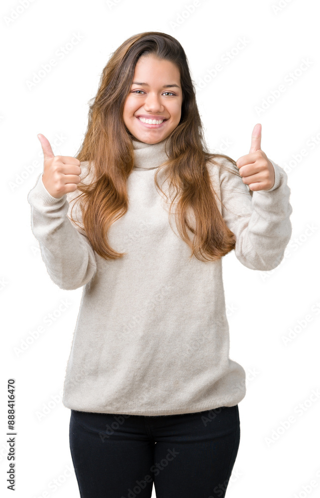 Young beautiful brunette woman wearing turtleneck sweater over isolated background success sign doing positive gesture with hand, thumbs up smiling and happy. Looking at the camera. Young beautiful brunette woman wearing turtleneck sweater over isolated background success sign doing positive gesture with hand, thumbs up smiling and happy. Looking at the camera.