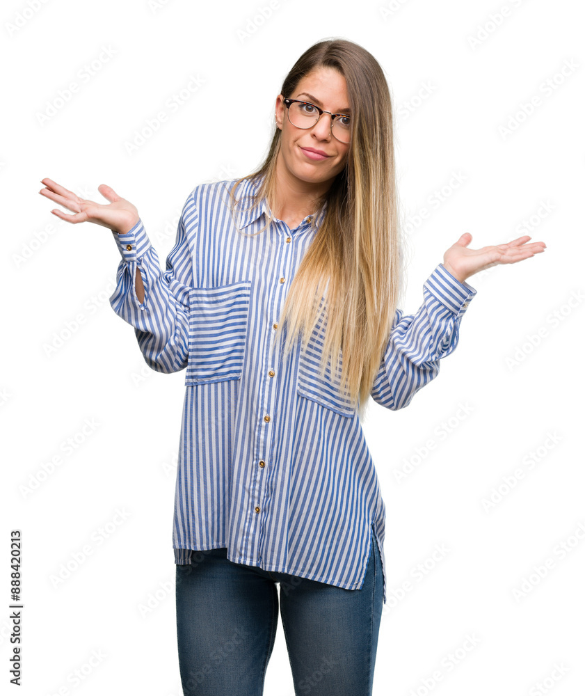 Beautiful young woman wearing elegant shirt and glasses clueless and confused expression with arms and hands raised. Doubt concept. Beautiful young woman wearing elegant shirt and glasses clueless and confused expression with arms and hands raised. Doubt concept.