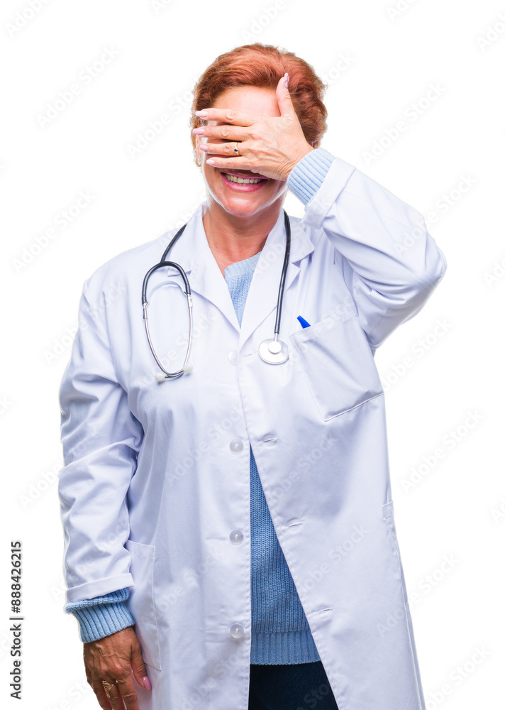Senior caucasian doctor woman wearing medical uniform over isolated background smiling and laughing with hand on face covering eyes for surprise. Blind concept. Senior caucasian doctor woman wearing medical uniform over isolated background smiling and laughing with hand on face covering eyes for surprise. Blind concept.