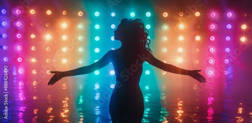 Silhouette of Woman Performing on Stage With Colored Lights