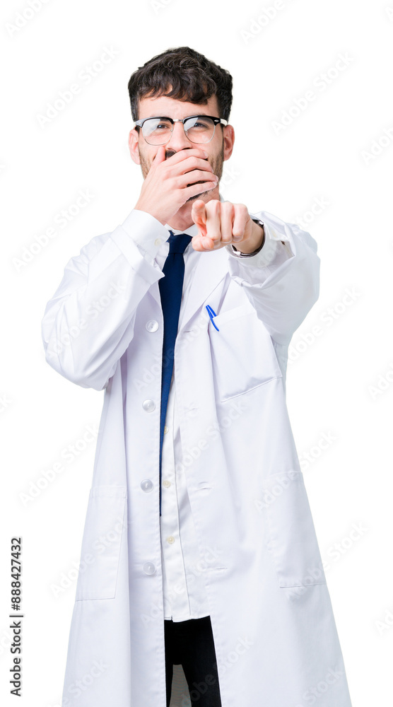 Young professional scientist man wearing white coat over isolated background Laughing of you, pointing to the camera with finger hand over mouth, shame expression Young professional scientist man wearing white coat over isolated background Laughing of you, pointing to the camera with finger hand over mouth, shame expression