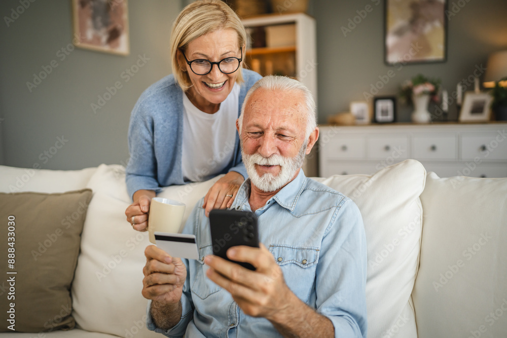 Senior couple buy online whit credit card on mobile phone at home Senior couple buy online whit credit card on mobile phone at home