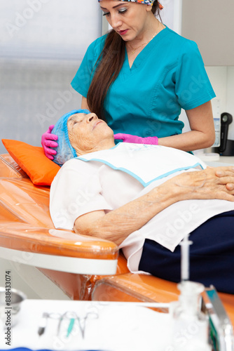 Senior adult patient at the dermatologists office being prepared by medical assistant the for a biopsy