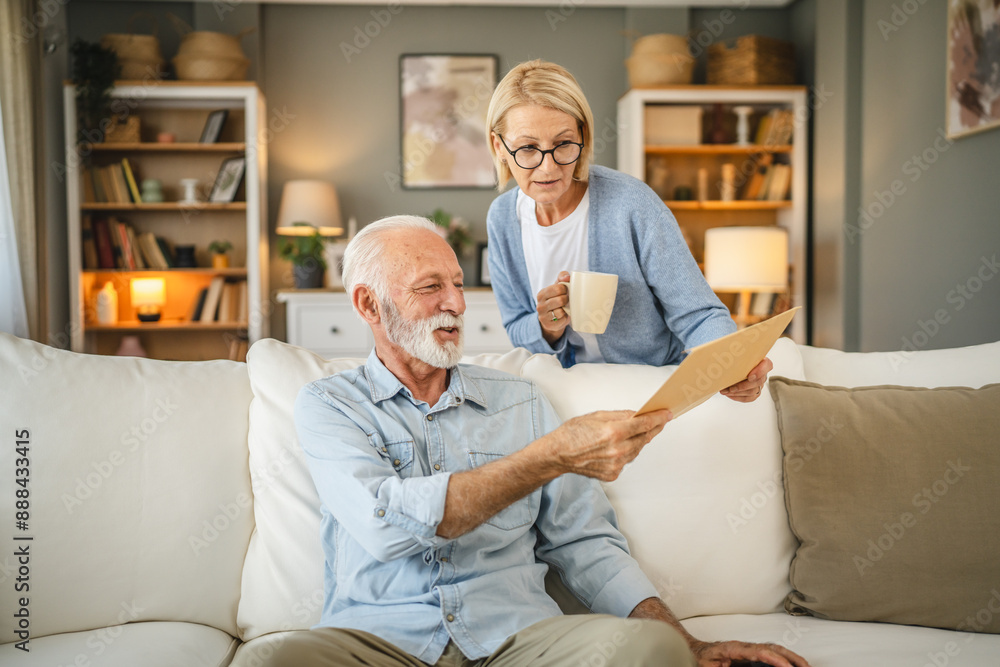 Senior couple receive a letter document from envelope together at home Senior couple receive a letter document from envelope together at home
