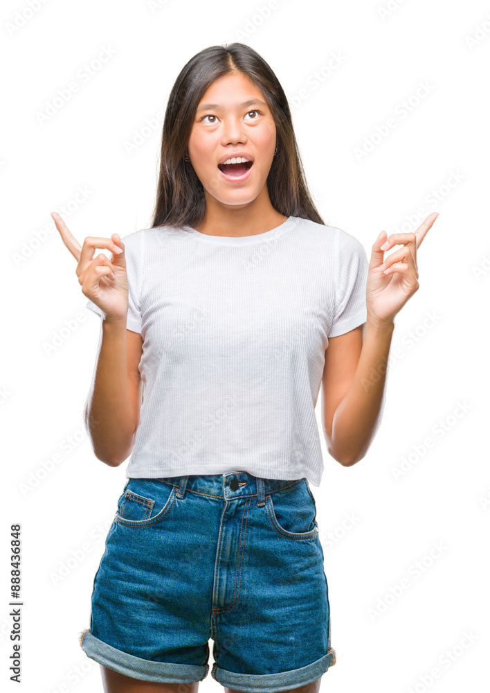 Young asian woman over isolated background amazed and surprised looking up and pointing with fingers and raised arms. Young asian woman over isolated background amazed and surprised looking up and pointing with fingers and raised arms.