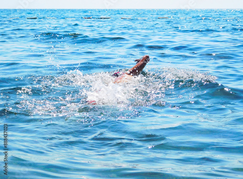 A man swims in the sea. Photo taken on a warm July day