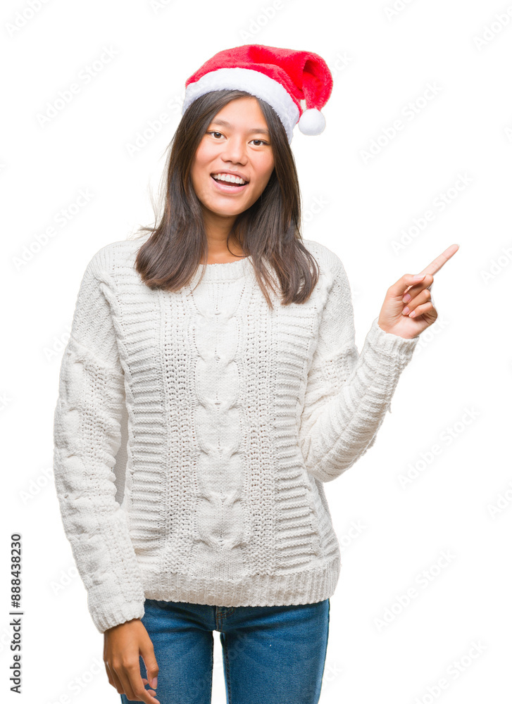Young asian woman wearing christmas hat over isolated background with a big smile on face, pointing with hand and finger to the side looking at the camera. Young asian woman wearing christmas hat over isolated background with a big smile on face, pointing with hand and finger to the side looking at the camera.