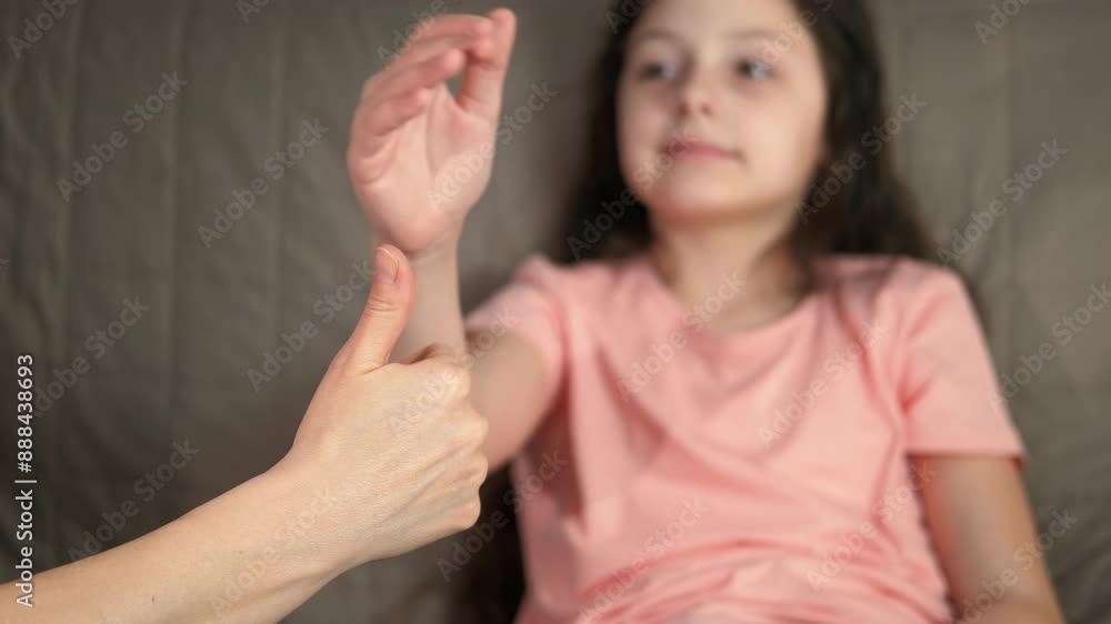 Child and mum show positive attitude. A positive little girl show the thumb up in the room. A concept of happy emotions in the family. Child and mum show positive attitude. A positive little girl show the thumb up in the room. A concept of happy emotions in the family.