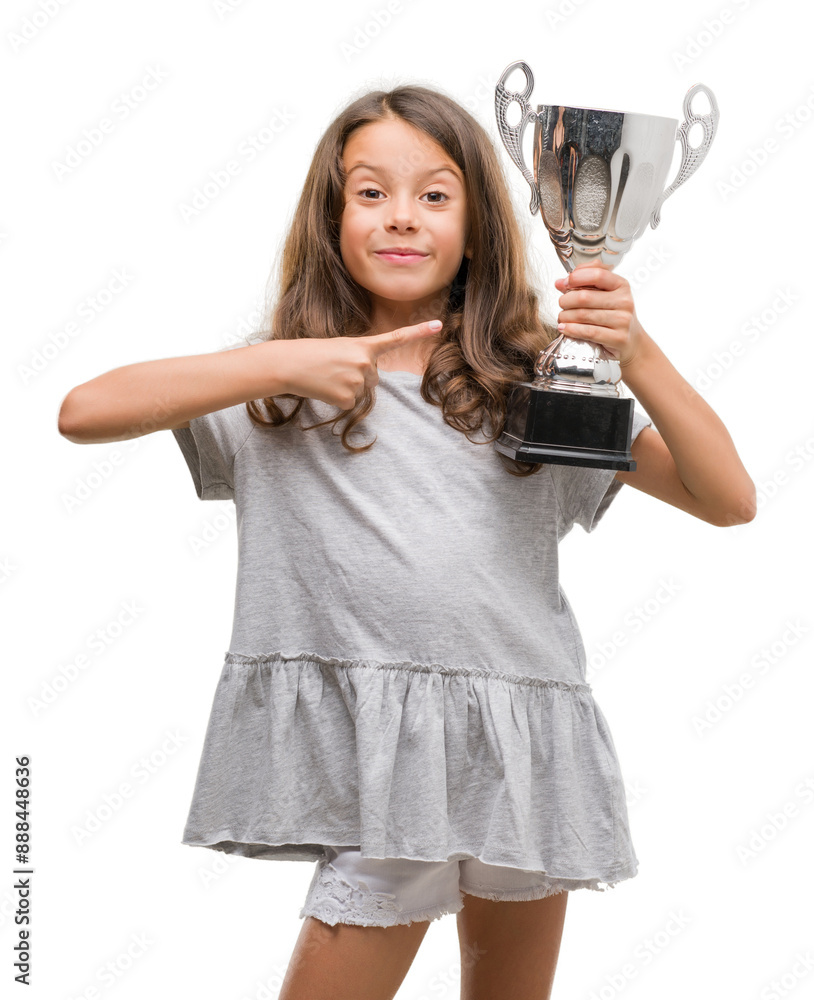 Brunette hispanic girl holding a trophy very happy pointing with hand and finger Brunette hispanic girl holding a trophy very happy pointing with hand and finger