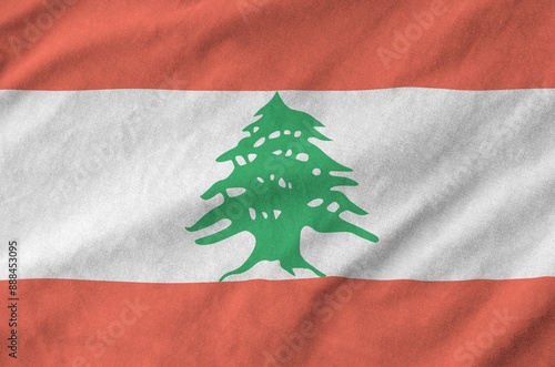 Lebanon flag depicted on folded wavy fabric of old cloth close up photo