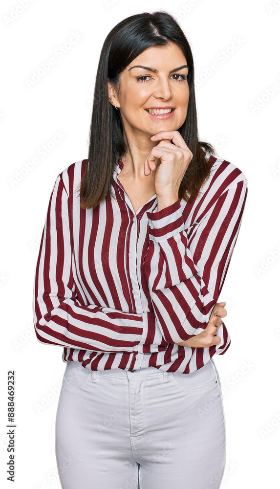 Beautiful brunette woman wearing striped shirt looking confident at the camera with smile with crossed arms and hand raised on chin. thinking positive. Beautiful brunette woman wearing striped shirt looking confident at the camera with smile with crossed arms and hand raised on chin. thinking positive.
