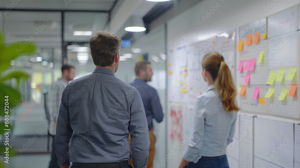 Obraz premium Business Collaboration: Professionals engaged in a discussion in a modern office with glass walls and sticky notes. Perfect for themes of teamwork, brainstorming, and corporate environment