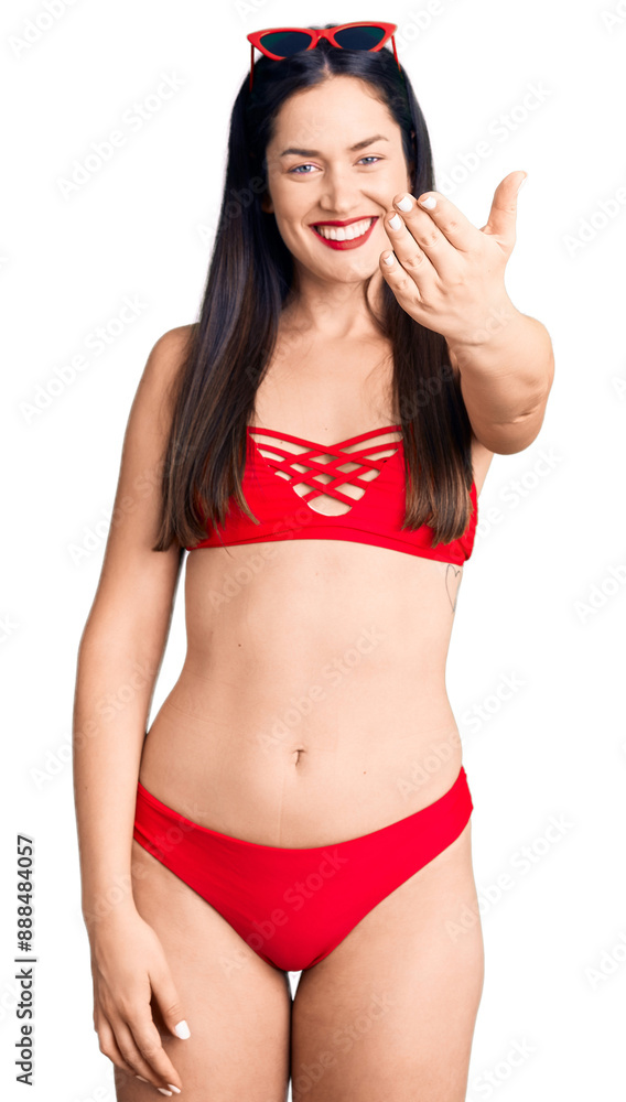 Young beautiful caucasian woman wearing bikini smiling friendly offering handshake as greeting and welcoming. successful business.