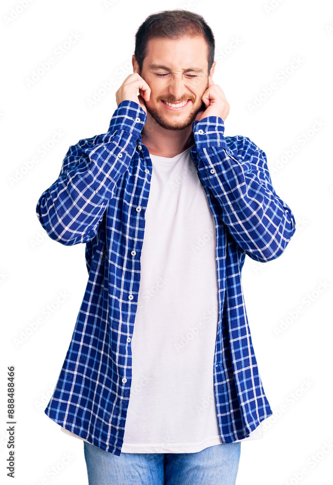 Young handsome caucasian man wearing casual clothes covering ears with fingers with annoyed expression for the noise of loud music. deaf concept. Young handsome caucasian man wearing casual clothes covering ears with fingers with annoyed expression for the noise of loud music. deaf concept.