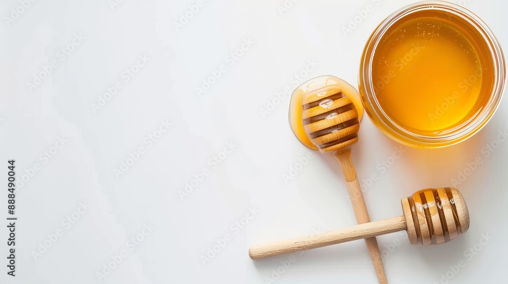 Top view of a honey jar with a wooden honey dipper on a white background with copy space Top view of a honey jar with a wooden honey dipper on a white background with copy space