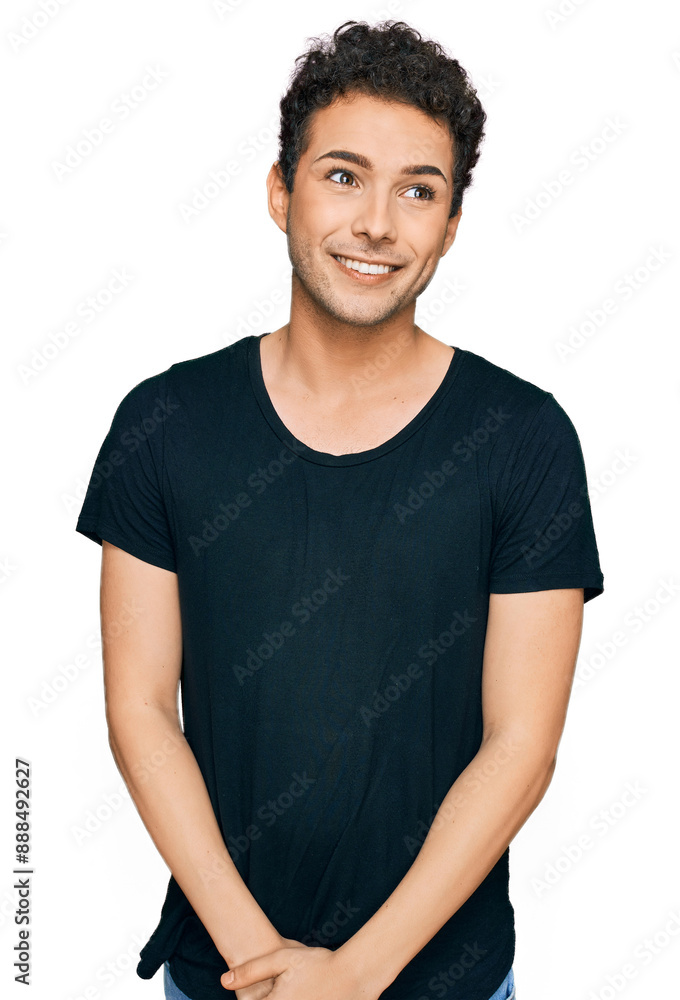 Young handsome man wearing casual black t shirt looking away to side with smile on face, natural expression. laughing confident. Young handsome man wearing casual black t shirt looking away to side with smile on face, natural expression. laughing confident.