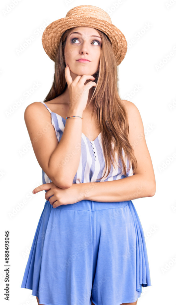 Young beautiful blonde woman wearing summer hat with hand on chin thinking about question, pensive expression. smiling with thoughtful face. doubt concept. Young beautiful blonde woman wearing summer hat with hand on chin thinking about question, pensive expression. smiling with thoughtful face. doubt concept.