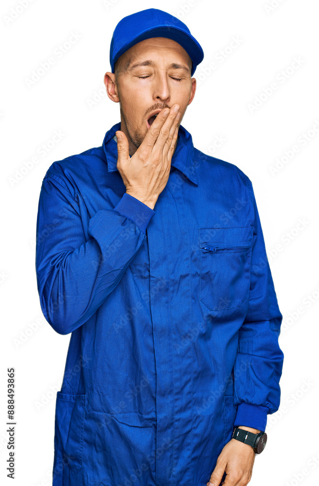Bald man with beard wearing builder jumpsuit uniform bored yawning tired covering mouth with hand. restless and sleepiness. Bald man with beard wearing builder jumpsuit uniform bored yawning tired covering mouth with hand. restless and sleepiness.