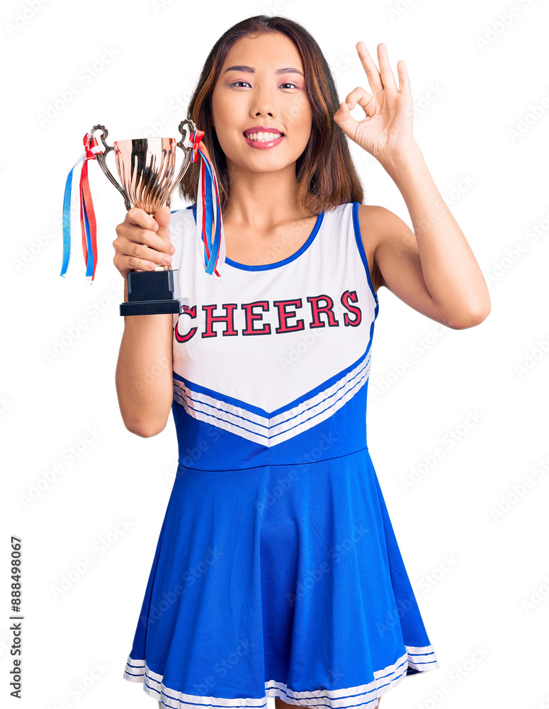 Youn beautiful asian girl wearing cheerleader uniform holding champion trophy doing ok sign with fingers, smiling friendly gesturing excellent symbol Youn beautiful asian girl wearing cheerleader uniform holding champion trophy doing ok sign with fingers, smiling friendly gesturing excellent symbol