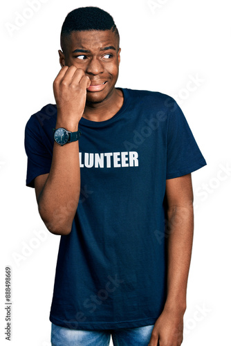 Young african american man wearing volunteer t shirt looking stressed and nervous with hands on mouth biting nails. anxiety problem.