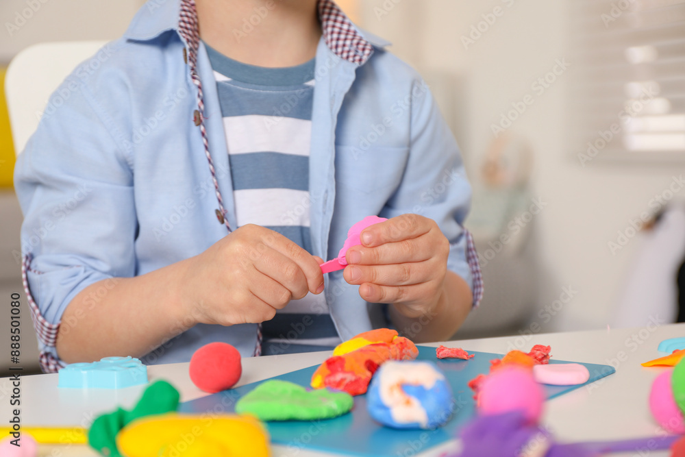 Little boy sculpting with play dough at table indoors, closeup Little boy sculpting with play dough at table indoors, closeup